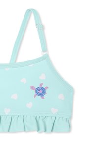 Haut de bain bleu clair avec des motifs de cœurs blancs, ourlet volanté et un graphisme de tortue dans des nuances de violet et de bleu. Bretelles ajustables.