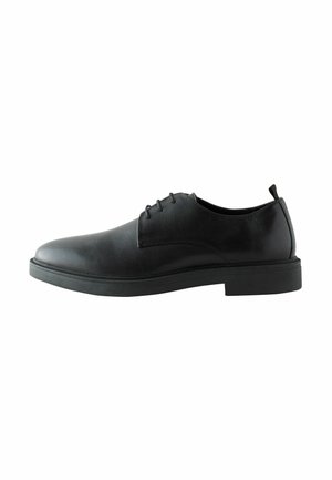 Sorte læder dress sko med en glat overflade, rund tå, seks øskner til snørebånd, flad gummisål og subtil hæl.