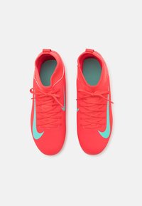 Baskets de sport rouges avec une surface texturée, présentant des accents turquoise et des lacets. Le design comprend un logo Nike bien visible sur chaque chaussure.