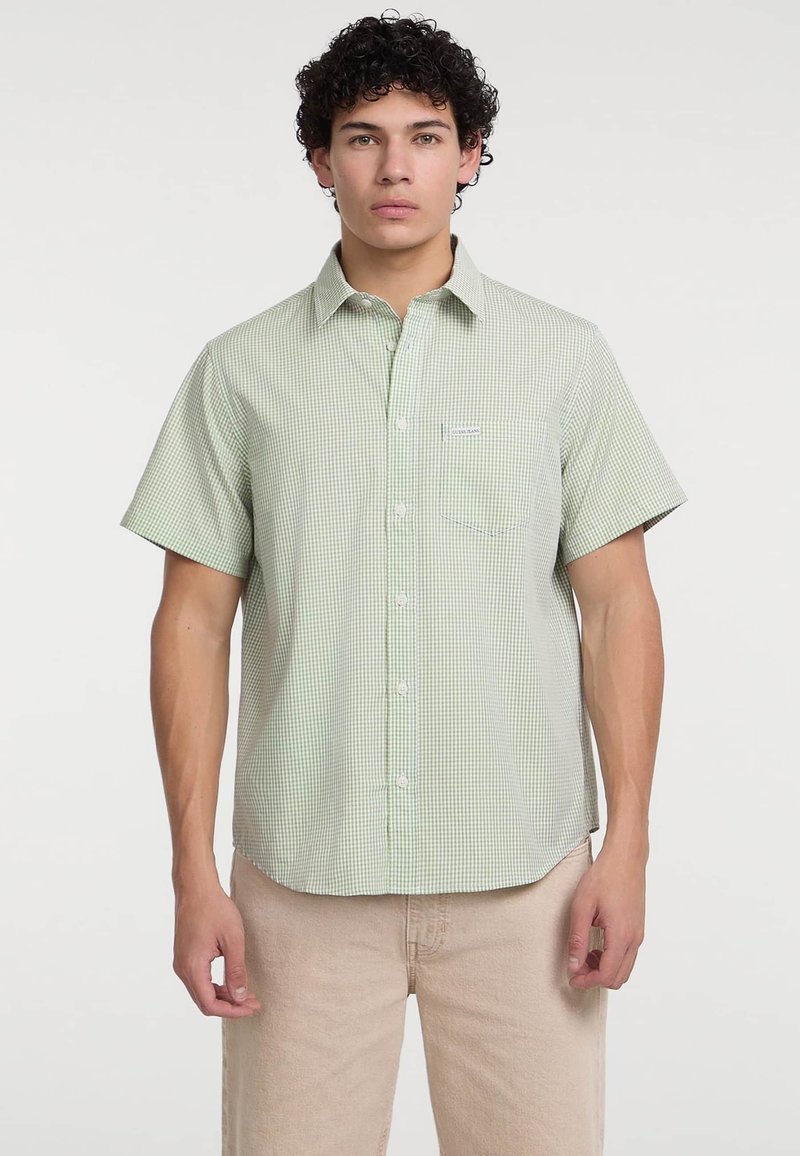Camicia a maniche corte con un motivo a quadri verde e bianco, realizzata in tessuto leggero, con colletto e taschino frontale.