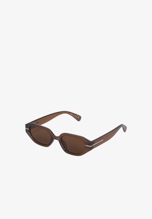 Brune ovale solbriller med transparent plaststel og mørke tonede linser, vist mod hvid baggrund.