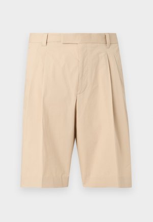 Beige, op knielengte gesneden op maat gemaakte short met riemlussen, plooien aan de voorkant en een verborgen ritssluiting.
