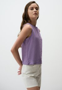 Lavendelkleurig mouwloos topje met een ronde halslijn en rechte snit, gecombineerd met lichtbeige shorts. Soepele stof met een minimalistisch ontwerp.