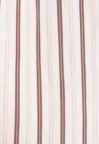 Tissu blanc avec des rayures verticales marron de différentes nuances et largeurs formant un motif régulier.