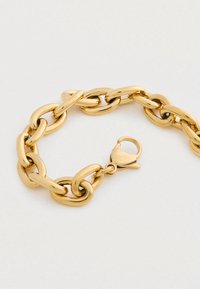 Χρυσό chunky βραχιόλι με οβάλ κρίκους και κούμπωμα με στρίψιμο σε ανοιχτό φόντο.