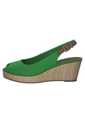 Sandale compensée verte à bout ouvert avec talon compensé à texture tissée et bride de cheville marron réglable avec boucle métallique.