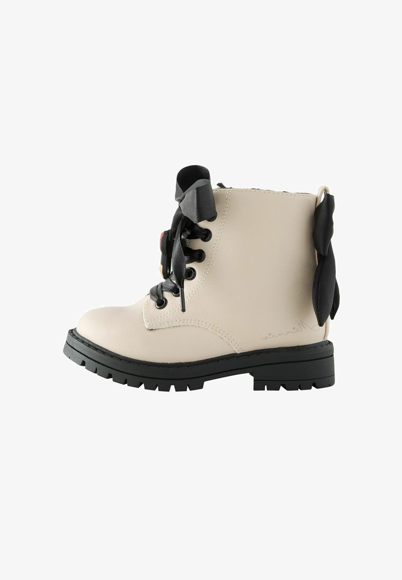 Beige leren enkelboot met zwarte veter, ronde neus, gestructureerde buitenkant en decoratieve strikaccent aan de achterkant; robuuste zool.