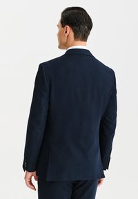 Granatowa marynarka wykonana z teksturowanej tkaniny, z pojedynczym rozcięciem, klapami w kształcie notcha oraz trzema guzikami na mankietach. Widok z tyłu pokazuje dopasowany krój.
