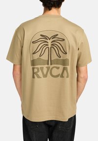 Katoenen tan t-shirt met een palmboom graphic en "RVCA" tekst in een donkerdere tint, met een ontspannen pasvorm en korte mouwen.