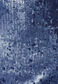 Tessuto di paillettes blu navy con dischi riflettenti rotondi disposti ravvicinati, creando una superficie lucida e testurizzata con riflessi di luce variabili.