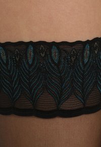 Meias pretas até a coxa com um padrão bordado de folhas em teal e preto na parte superior, apresentando um design texturizado e transparente.