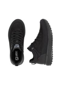 Des chaussures de sport noires avec une combinaison de matériaux synthétiques lisses et texturés, un design à lacets, et des semelles robustes pour une meilleure adhérence.