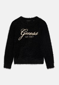 Maglione nero peloso con maniche lunghe, scollatura rotonda, con logo ricamato bianco e argento "Guess est.1981" sul davanti.
