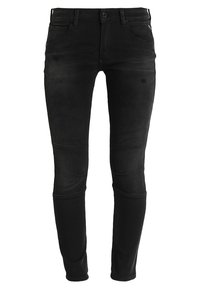 Jeans negros de corte ajustado, confeccionados en denim, con paneles en las rodillas y bolsillos estándar. Incluyen un cierre de botón y lazos para cinturón.