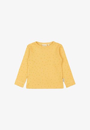 Camisa amarilla de manga larga con textura acanalada y pequeñas manchas naranjas. Presenta un escote redondeado y una etiqueta en la parte inferior izquierda.