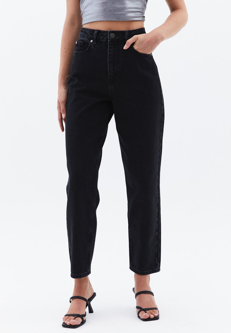 Jeans de mezclilla negros de cintura alta con corte recto, bolsillos frontales y cierre de botón, con una textura suave y un diseño minimalista.