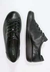 Svarta läderskor med rund tå, snörningsdesign och en slät yta. Platt gummisula med minimal mönstring och diskret märkning.