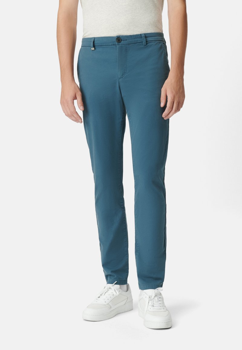 Męskie chinosy slim fit w bogatym kolorze teal, wykonane z lekkiego materiału, o gładkiej fakturze, z zapięciem na guzik i kieszeniami bocznymi.