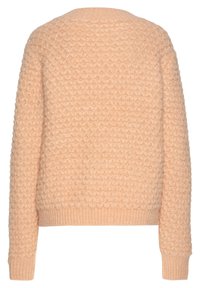 Texturierter pfirsichfarbener Pullover mit einem Blasenmusterdesign, gerippten Bündchen und Saum. Hat einen runden Ausschnitt und lange Ärmel.