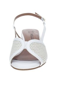 Sandalia blanca tipo slingback con detalle tejido en el empeine y una plantilla suave de color marrón. Presenta una correa ajustable en el tobillo y un diseño de punta abierta.