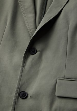 Blazer vert olive au design épuré, avec deux boutons noirs, des revers structurés et des détails de poche, le tout avec une texture de tissu lisse.