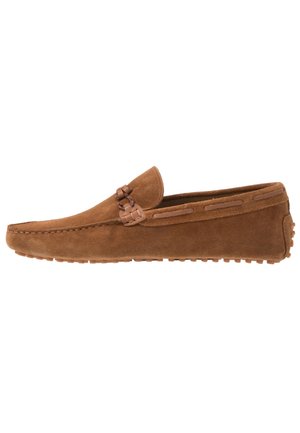 Mocassin marron en daim à enfiler avec semelle en caoutchouc et détail décoratif de lacet en cuir sur le côté, vu de profil.