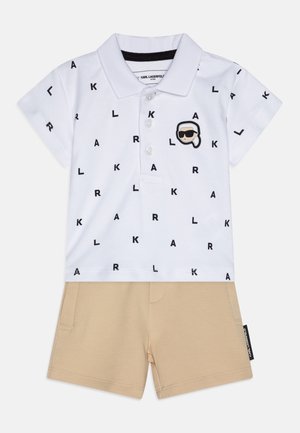 Witte polo met zwart "KL"-print en een logo patch, gecombineerd met beige shorts. Gemaakt van een katoenmix, met korte mouwen en een klassieke kraag.