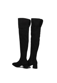 Zwarte boven-de-knie laarzen van zacht suede, met een blokhak en een rits aan de zijkant voor gemak bij het aantrekken. Gladde textuur zonder zichtbare patronen.