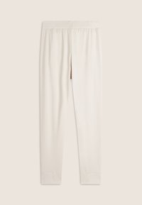 Leggings de color crema con una textura suave, cinturilla elástica y piernas ajustadas; presenta sutiles detalles de costura en los puños.