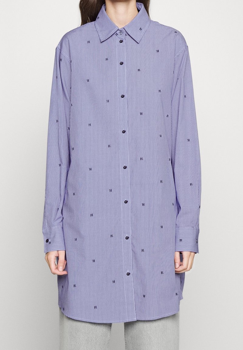 Lilla og hvidstribet langærmet skjorte med små broderede detaljer, knaplukning foran og klassisk krave.