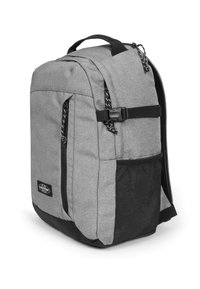 Mochila de tela gris con detalles en negro, que cuenta con dos bolsillos frontales con cremallera, un bolsillo lateral de malla y un asa superior resistente.