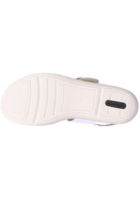 Suola di scarpa bianca con motivi di presa testurizzati, caratterizzata da una forma arrotondata e un design sagomato. Include un piccolo dettaglio del logo nero.