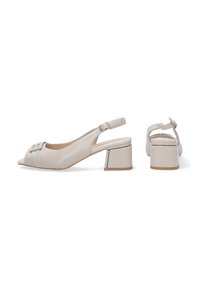 Slingback schoenen met een chunky hak in lichtbeige leer, met een spitse neuzen, decoratieve banddetails en een geometrisch hakontwerp.