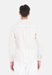 Camicia a maniche lunghe a righe con un motivo bianco e beige chiaro. Realizzata in tessuto leggero, presenta un colletto e polsini con bottoni.
