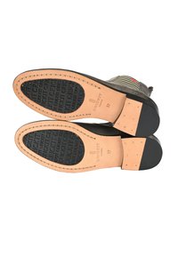 Scarpe in pelle con suole in gomma nera, caratterizzate da una superficie liscia e un motivo distintivo. Taglia 37 riportata sulla soletta.