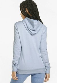Sudadera con capucha de color azul claro, hecha de tela texturizada, con puños ajustados y dobladillo acanalado. La vista trasera muestra la capucha y una silueta suave.