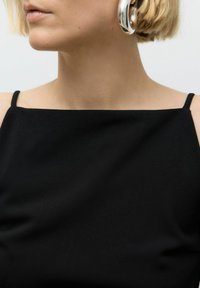 Top nero senza maniche con scollatura quadrata, realizzato in tessuto liscio. Presenta spalline minime e un design pulito e lineare.