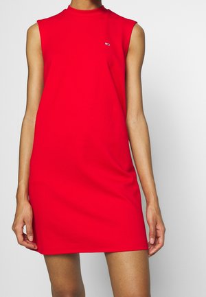 Rotes ärmelloses Kleid mit hohem Kragen, aus weichem Stoff gefertigt. Mit kleinem Logo auf der Brust, geradem Schnitt und über knielanger Länge.