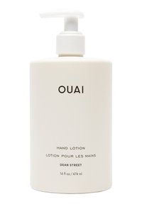 Vit, cylindrisk flaska med handlotion och pump. Etiketten har svart text: "OUAI HAND LOTION DEAN STREET 16 fl oz / 474 ml."