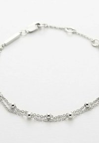 Zilveren kettingarmband met twee strengen, versierd met kleine bolvormige kralen die gelijkmatig zijn verdeeld. Sluiting met een rechthoekige schakel aan één uiteinde.