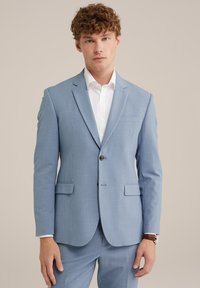 Helles Blaues Sakkos aus strukturiertem Stoff, mit einem Knopfverschluss, Reverskragen und zwei vorderen Taschen. Darunter ein weißes Hemd.
