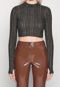 Černý, ribbovaný, dlouhý rukáv crop top vyrobený z texturované tkaniny s metalickými vlákny; spárován s lesklými hnědými kalhotami s vysokým pasem.