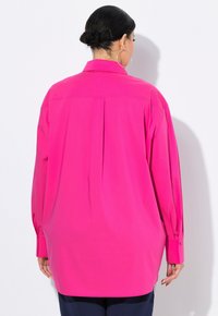 Langärmliges rosa Hemd mit einer Rückenfalte und geknöpften Manschetten, aus glattem Stoff gefertigt. Das Design zeichnet sich durch einen klassischen Kragen und eine lockere Passform aus.