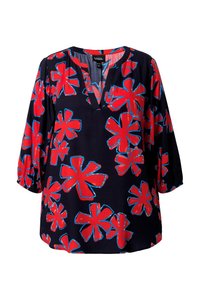 Blouse bleu marine avec de grands motifs floraux contourés en rouge et bleu, manches trois-quarts et encolure en V avec un petit col.