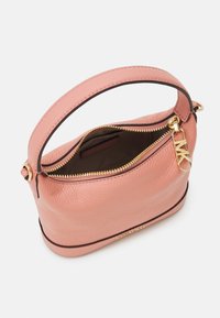 Bolso de mano de cuero rosa con forma estructurada, cremallera dorada y un asa corta. El interior presenta un forro marrón con una etiqueta de marca.