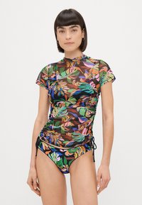 Top de banho de manga curta, com padrão floral em tecido transparente, apresentando laterais franzidas e gola alta. Parte de baixo de banho correspondente com um design vibrante.