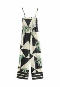 Svart och vit jumpsuit med gröna lövmönster, med en smockad bodice och justerbara axelband. Vid bendesign med randiga detaljer.