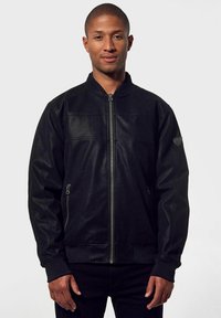Giacca bomber nera in pelle con zip frontale, due tasche laterali e polsini a costine. Presenta un design semplice senza motivi visibili.