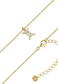 Zelta ķēde ar dimantu rotātu Dvīņu simbolu piekariņu, kas aprīkots ar omāru aizdari un regulējamu garumu.