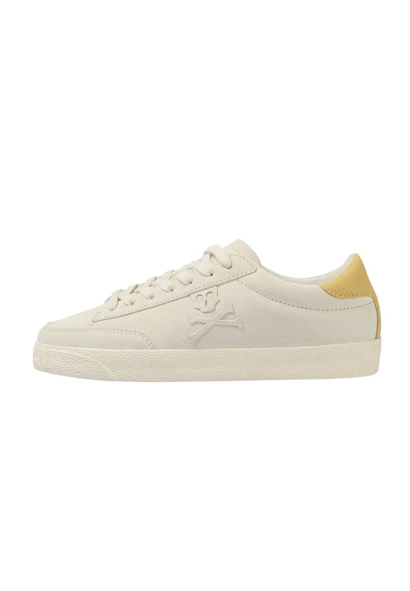 Sneaker in camoscio beige con suola in gomma bianca, caratterizzata da un accento giallo sul tallone e un logo di teschio e ossa incrociate sul lato.
